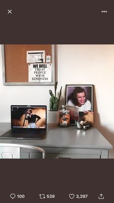 a laptop computer sitting on top of a wooden desk next to a potted plant