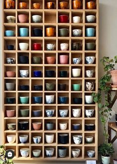 a wooden shelf filled with lots of different colored bowls