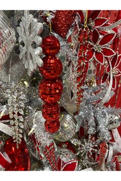 red and silver ornaments are hanging on a christmas tree