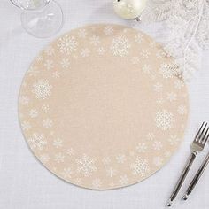 a place mat with snowflakes on it next to silverware