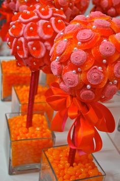 orange candies are arranged in vases with red bows