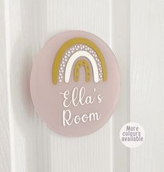 a pink and yellow door hanger that says ella's room