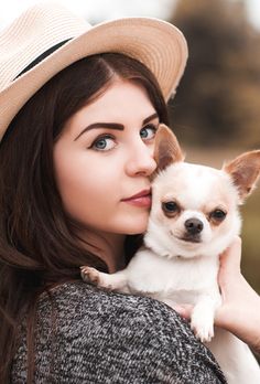 a woman holding a small dog in her arms