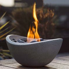 a fire pit sitting on top of a wooden table