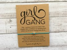 a card with the words girl gang on it and a blue string attached to it