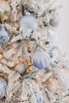 a white christmas tree with blue and silver ornaments