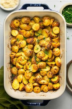 a casserole dish filled with potatoes and parsley