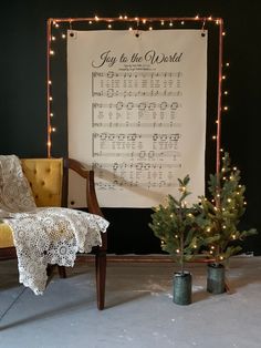 a christmas tree is next to an old fashioned chair with sheet music written on it