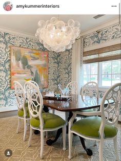 a dining room table with four chairs and a chandelier