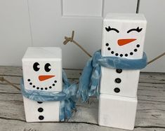 two snowmen made out of toilet paper sitting next to each other