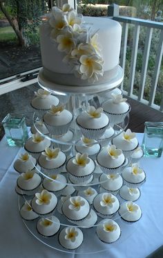 a wedding cake and cupcakes on a table