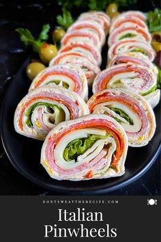 italian pinwheels with cheese, meat and vegetables on a black serving platter