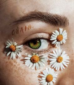 a woman's face with daisies painted on her cheek and the words cha in front of her eyes