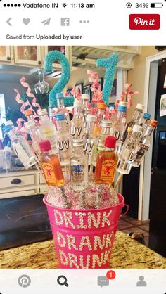 a pink bucket filled with bottles on top of a counter