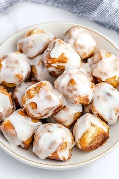 a white plate topped with cinnamon rolls covered in icing