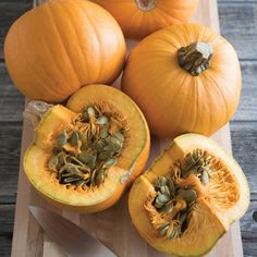 three pumpkins cut in half on a cutting board