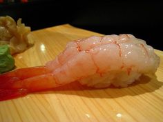 a piece of sushi on a wooden plate