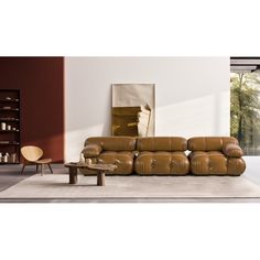 a brown leather couch sitting on top of a white floor next to a wooden table