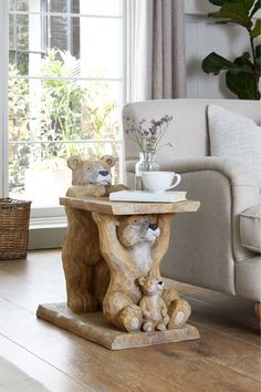 a table with two bears on it in front of a couch and coffee cup holder