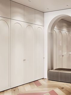 a bedroom with white closets and pink rugs on the wooden floor next to it