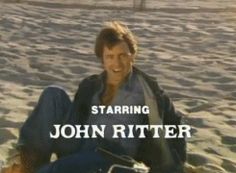 a man sitting on top of a sandy beach