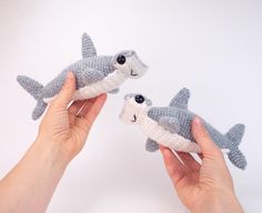 two handmade stuffed animals in the shape of shark and shark toothpicks are being held by someone's hands