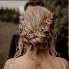 the back of a woman's head wearing a wedding hair piece with leaves on it