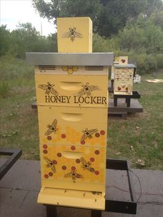 a beehive sitting on top of a wooden table next to another box filled with bees