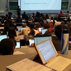 a classroom full of students with laptops