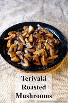 a black plate topped with mushrooms on top of a table