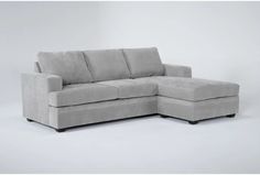 a gray sectional couch sitting on top of a white floor