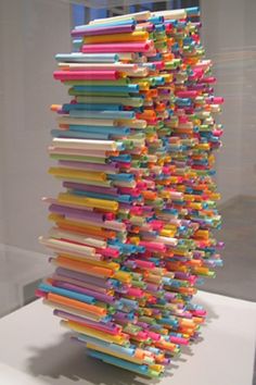 a sculpture made out of colored papers on a white surface in front of a window