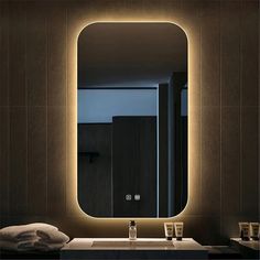 a bathroom with a sink, mirror and lights on the wall above it's counter