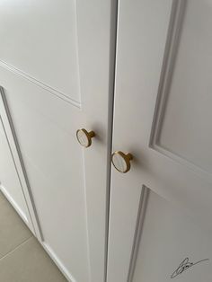 two white cupboards with brass handles and knobs