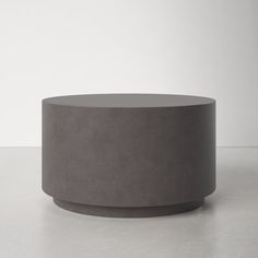 a round concrete table sitting on top of a white floor