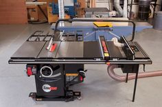 a table sawing machine sitting on top of a workbench in a garage