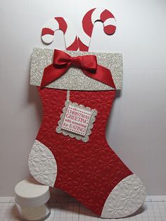 a red and white christmas stocking hanging on the wall next to a toilet paper roll