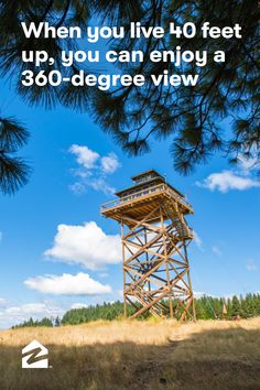 a tall wooden tower sitting in the middle of a field next to a tree line