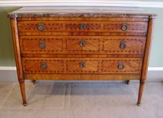 an antique chest of drawers with marble top