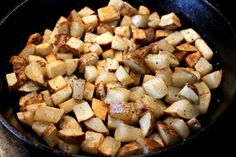 a pan filled with cooked potatoes on top of a stove