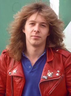 a man with long hair wearing a red leather jacket