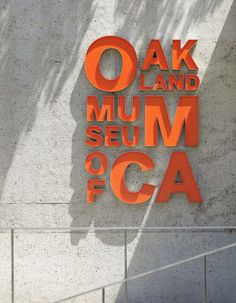 an orange sign on the side of a building that says oak and mum seum foca