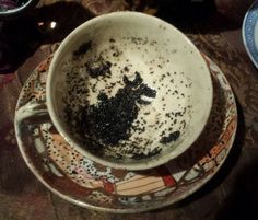 a white cup filled with dirt sitting on top of a saucer