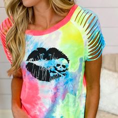 a woman wearing a tie dye shirt with lipstick on it