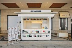 a small store front on the side of a building with signage and posters in it