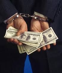 a person in a suit holding money with handcuffs on their hands and one dollar bill being held by two hands