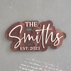 a wooden sign that says the smiths est 202 on it's side wall