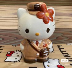 a hello kitty figurine holding a hot dog in it's hand on a table