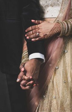 the bride and groom are holding hands