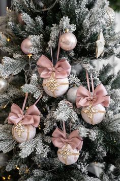 christmas ornaments are hanging on the tree in pink and silver colors, with gold accents